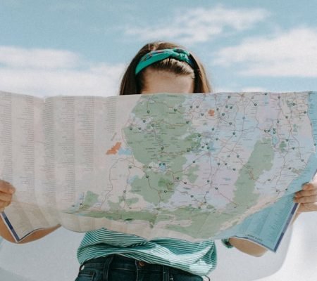 A woman holds a map while traveling through the scenic desert of California, USA.